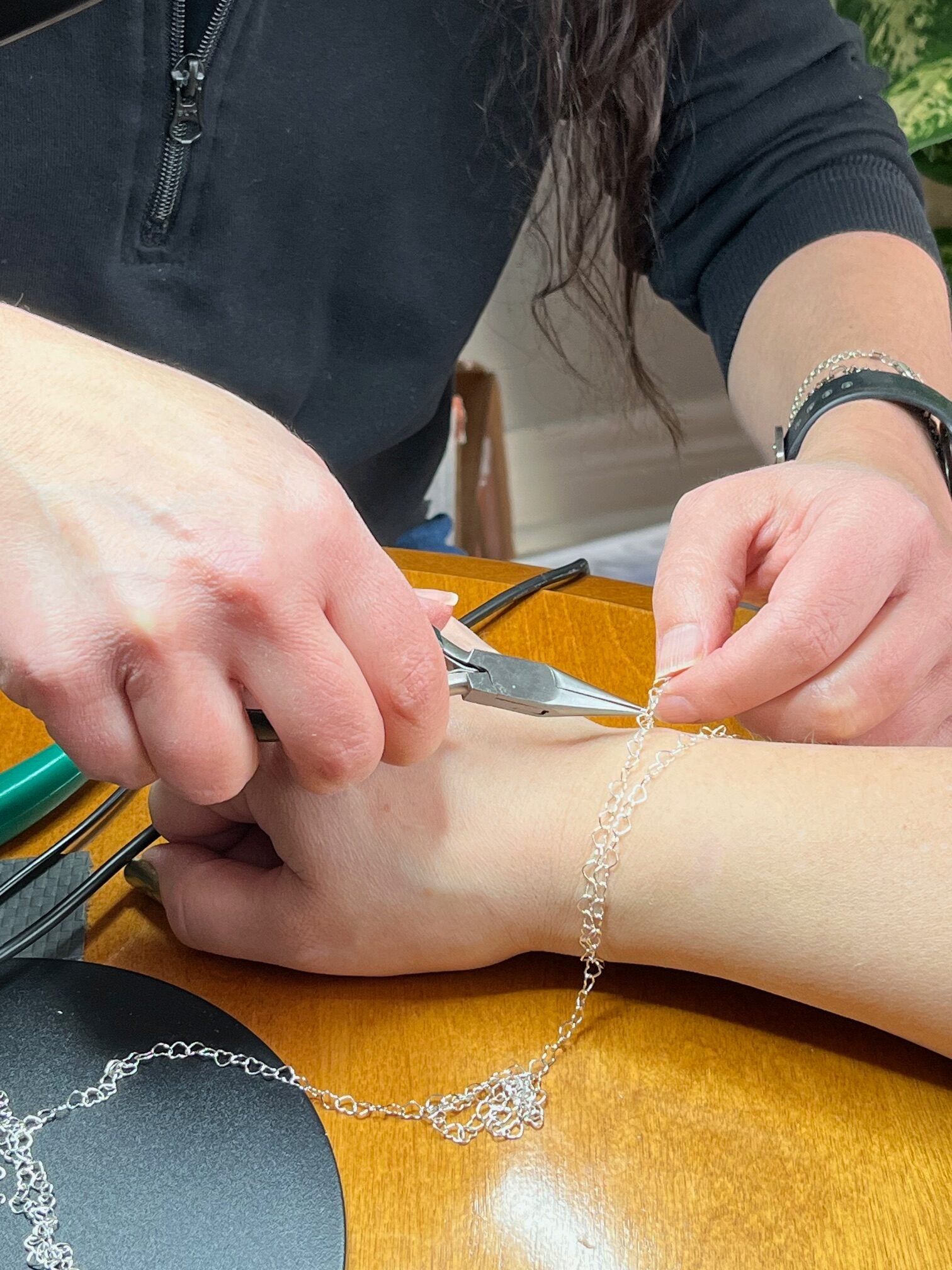 Tricia measuring a chain around a wrist