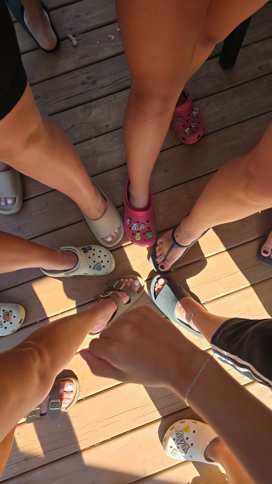 Friends showing their permanent jewelry at an outdoor gathering