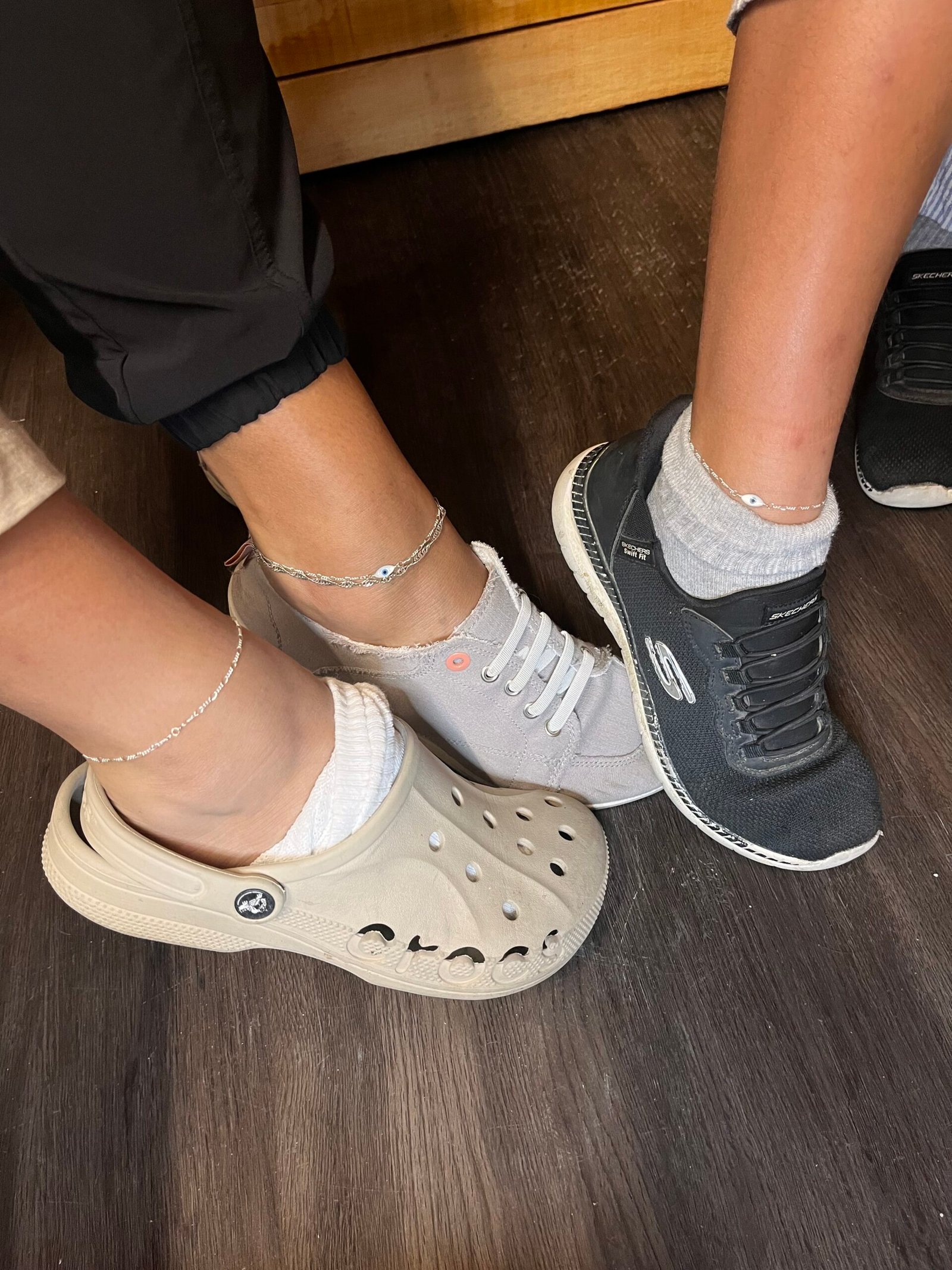 Three silver anklets worn with everyday shoes