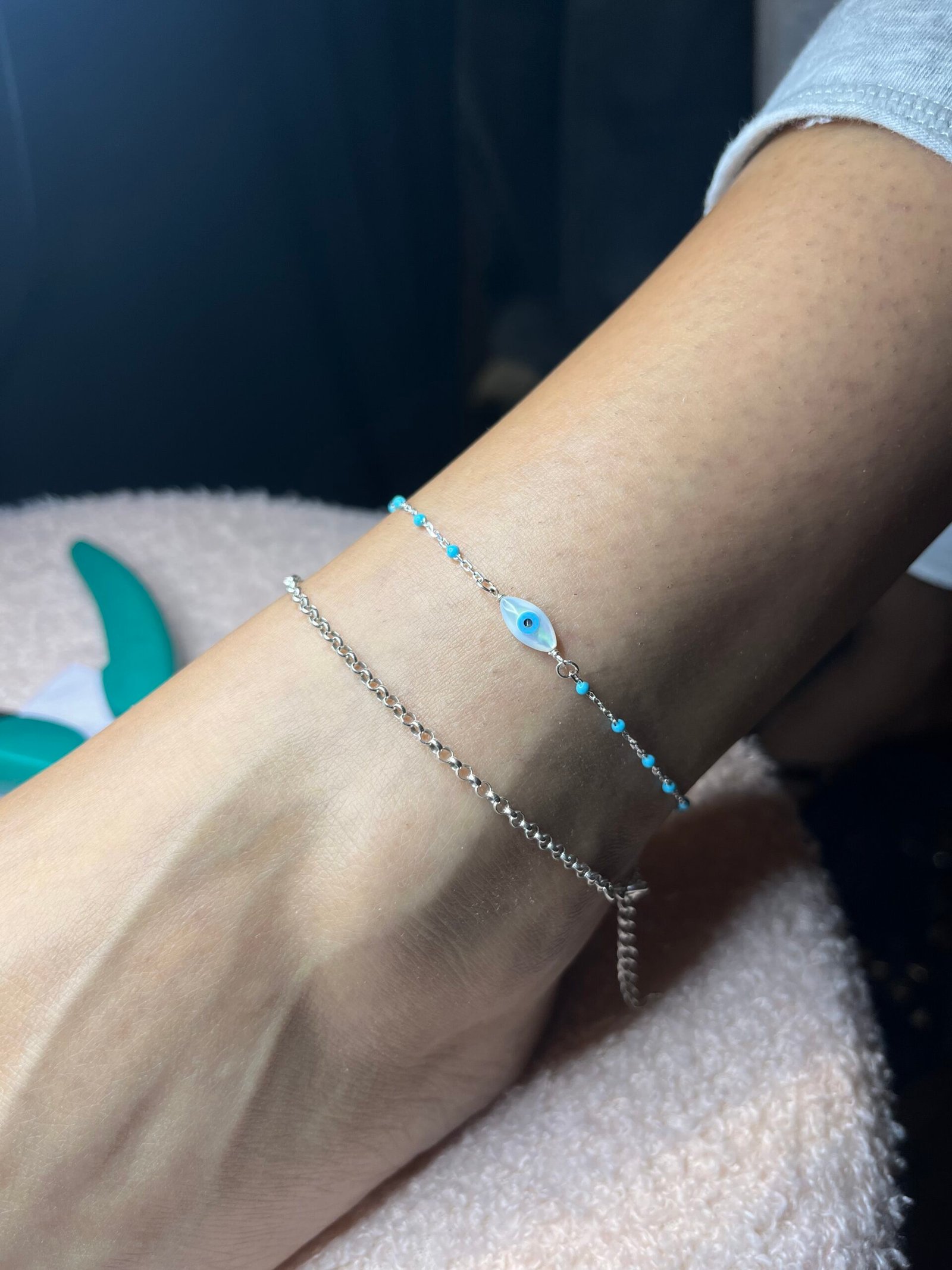 Delicate bracelets and a blue-eye charm, worn every day
