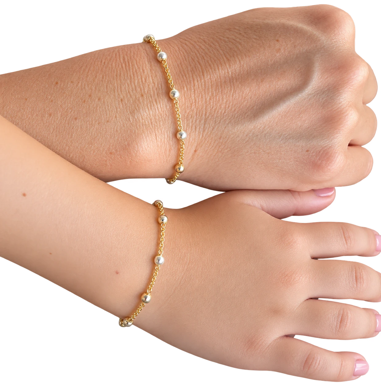 Two hands wearing matching gold and silver bracelets